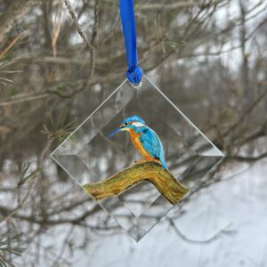 "Hand-painted Kingfisher suncatcher, a vibrant glass art piece hanging in a window. Perfect for bird lovers and nature-inspired home decor."